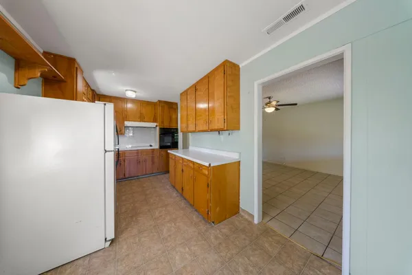 a view of kitchen with refrigerator cabinets and a counter top space