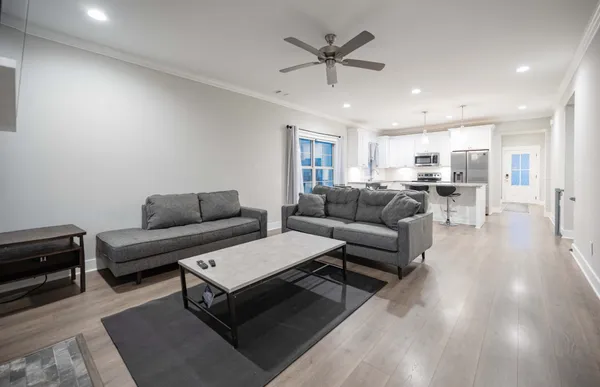 a living room with furniture and a view of kitchen