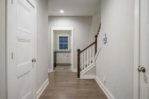 a view of a hallway with wooden floor and entryway