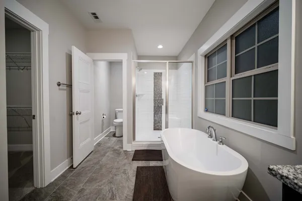 a bathroom with a white tub sink shower and a toilet