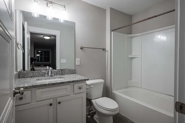 a bathroom with a granite countertop sink toilet and shower