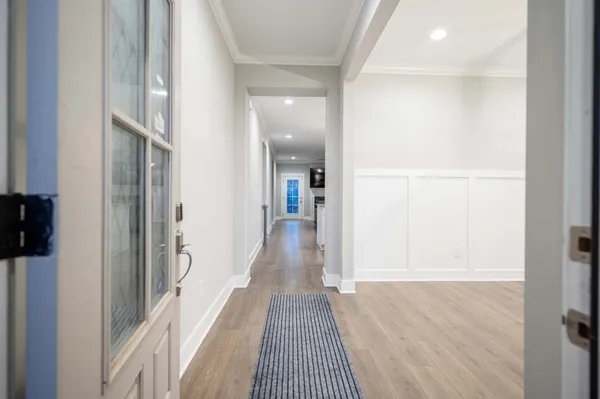 a view of a hallway with wooden floor and staircase