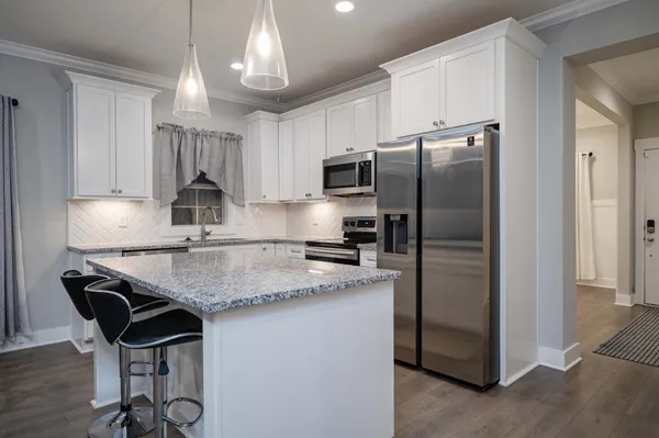 a kitchen with kitchen island a counter top space cabinets and stainless steel appliances
