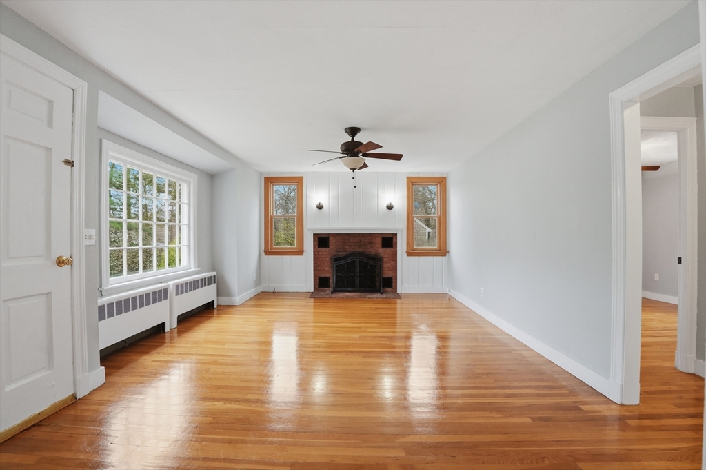 590 Sandwich Road Falmouth, MA 02536 - Photo 11 of 42 a view of a livingroom with wooden floor a fireplace and window