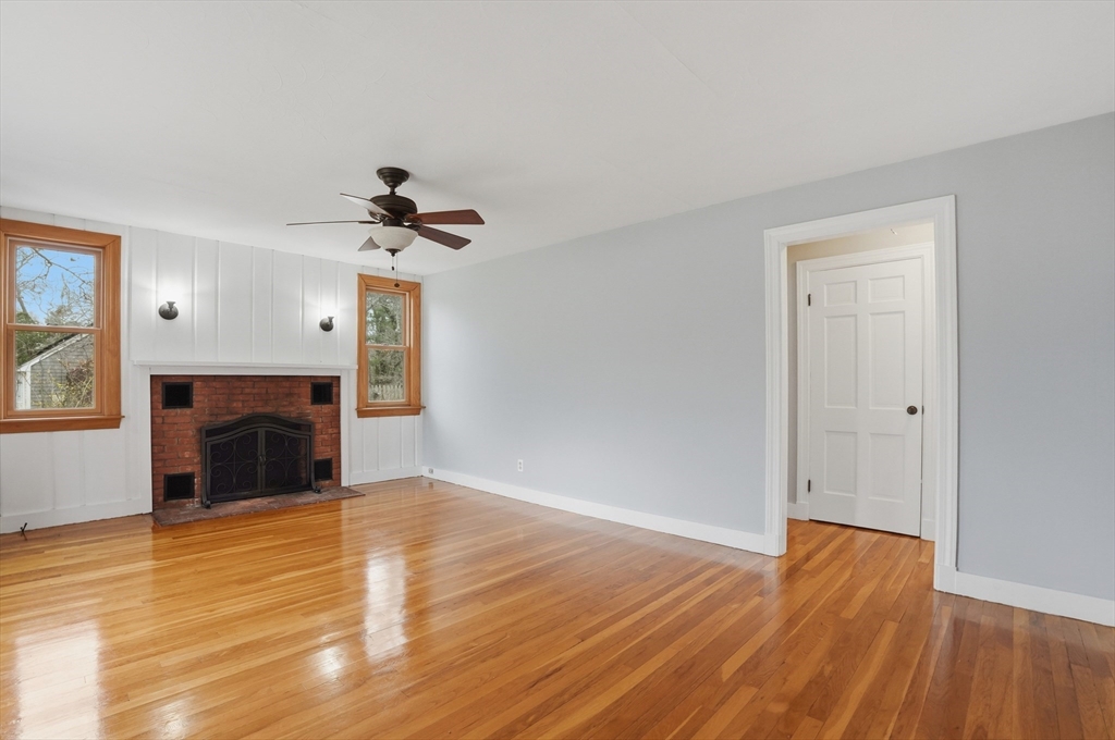 590 Sandwich Road Falmouth, MA 02536 - Photo 13 of 42 a view of an empty room with wooden floor fireplace and a window