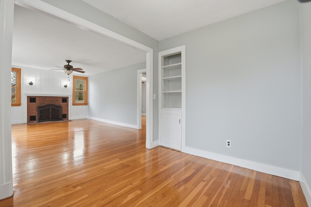 590 Sandwich Road Falmouth, MA 02536 - Photo 15 of 42 a view of empty room with wooden floor and fireplace