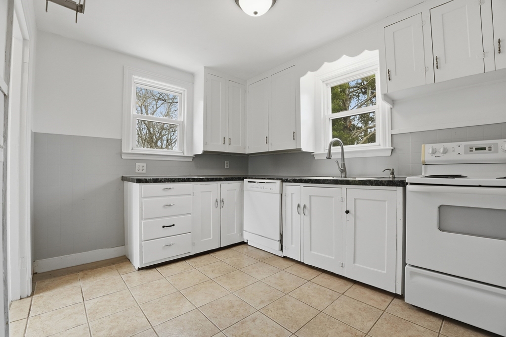 590 Sandwich Road Falmouth, MA 02536 - Photo 2 of 42 a kitchen with granite countertop white cabinets and window