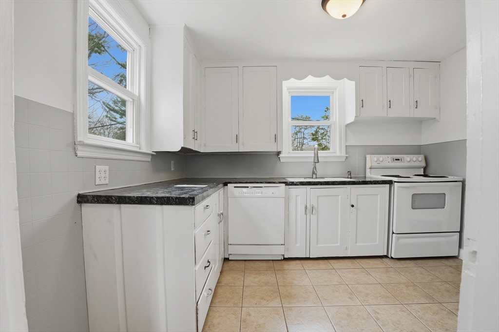 590 Sandwich Road Falmouth, MA 02536 - Photo 3 of 42 a kitchen with granite countertop white cabinets and stainless steel appliances