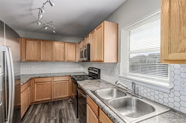 a kitchen that has a sink cabinets counter space and appliances
