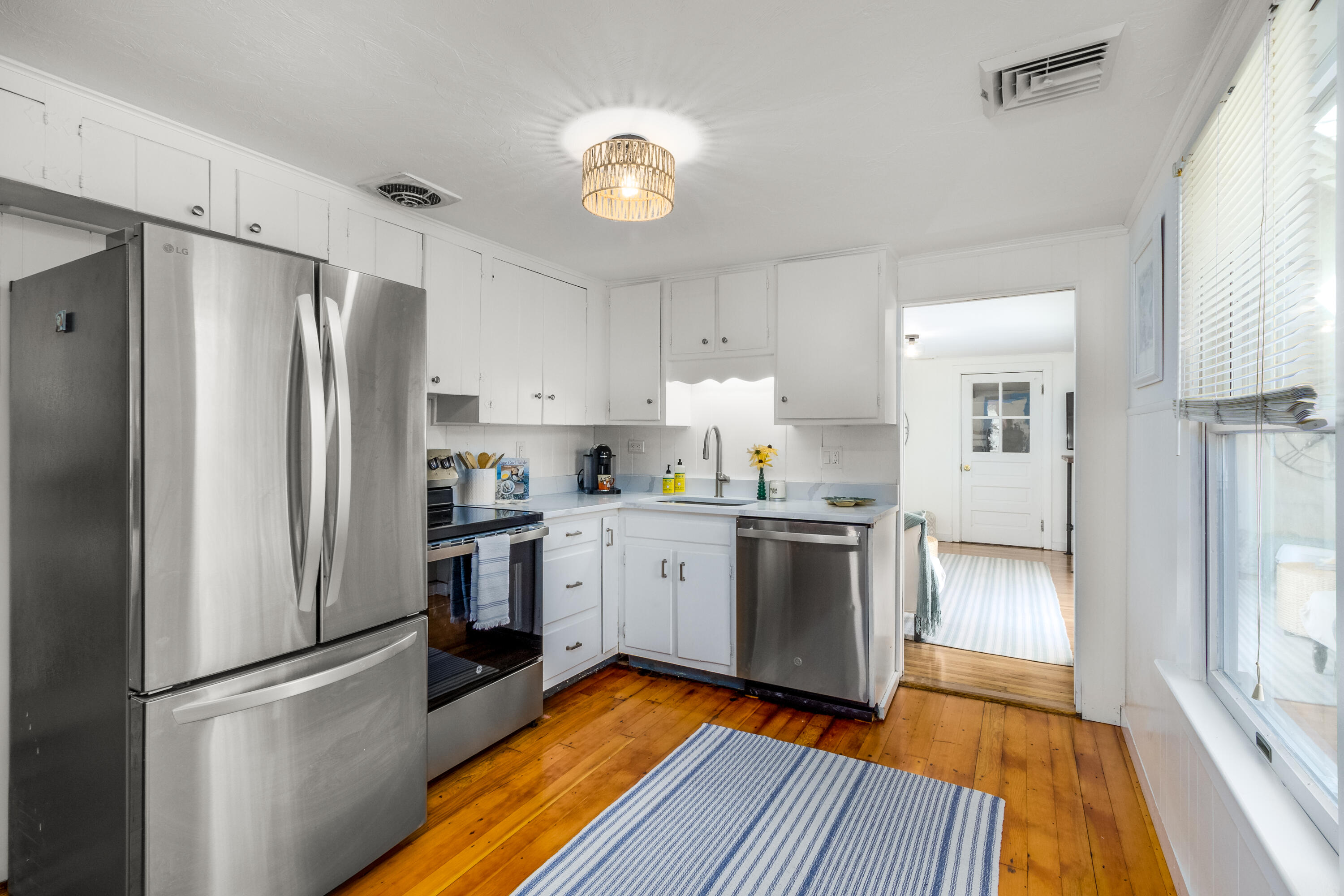 429 Paine's Creek Road Brewster, MA 02631 - Photo 8 of 35 a kitchen with a refrigerator a sink and dishwasher with wooden floor
