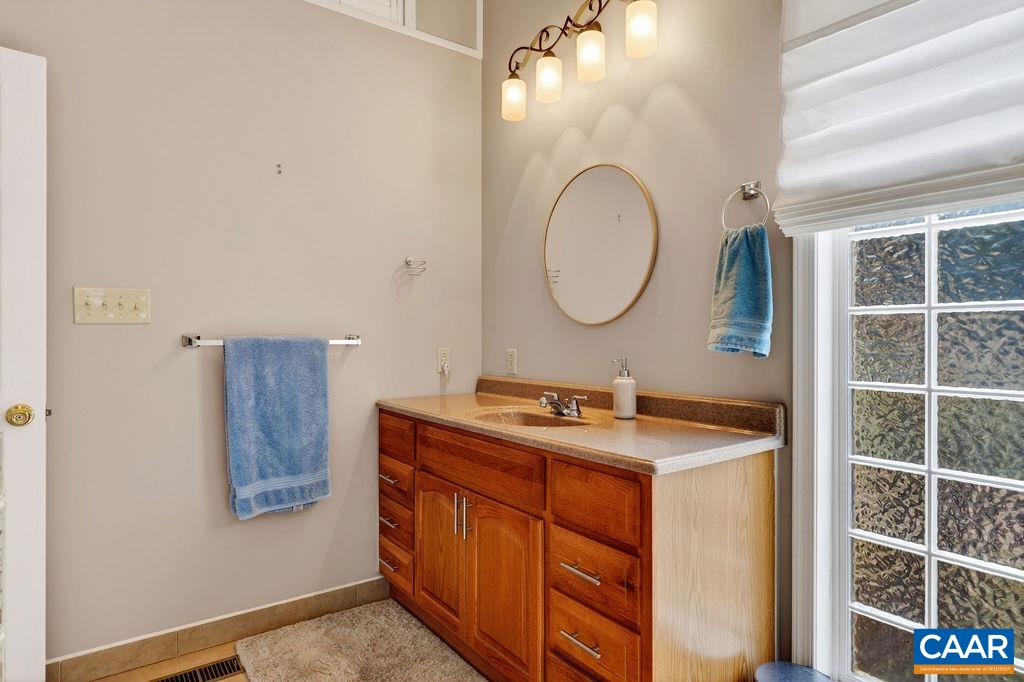 62 Summit Court Roseland, VA 22967 - Photo 33 of 75 a bathroom with a granite countertop sink a mirror a vanity and a shower