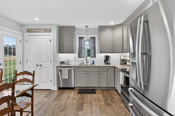 a kitchen with granite countertop a refrigerator stove and sink