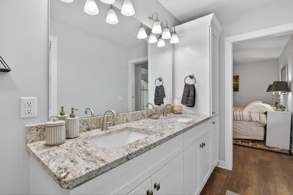a bathroom with a granite countertop sink toilet and mirror