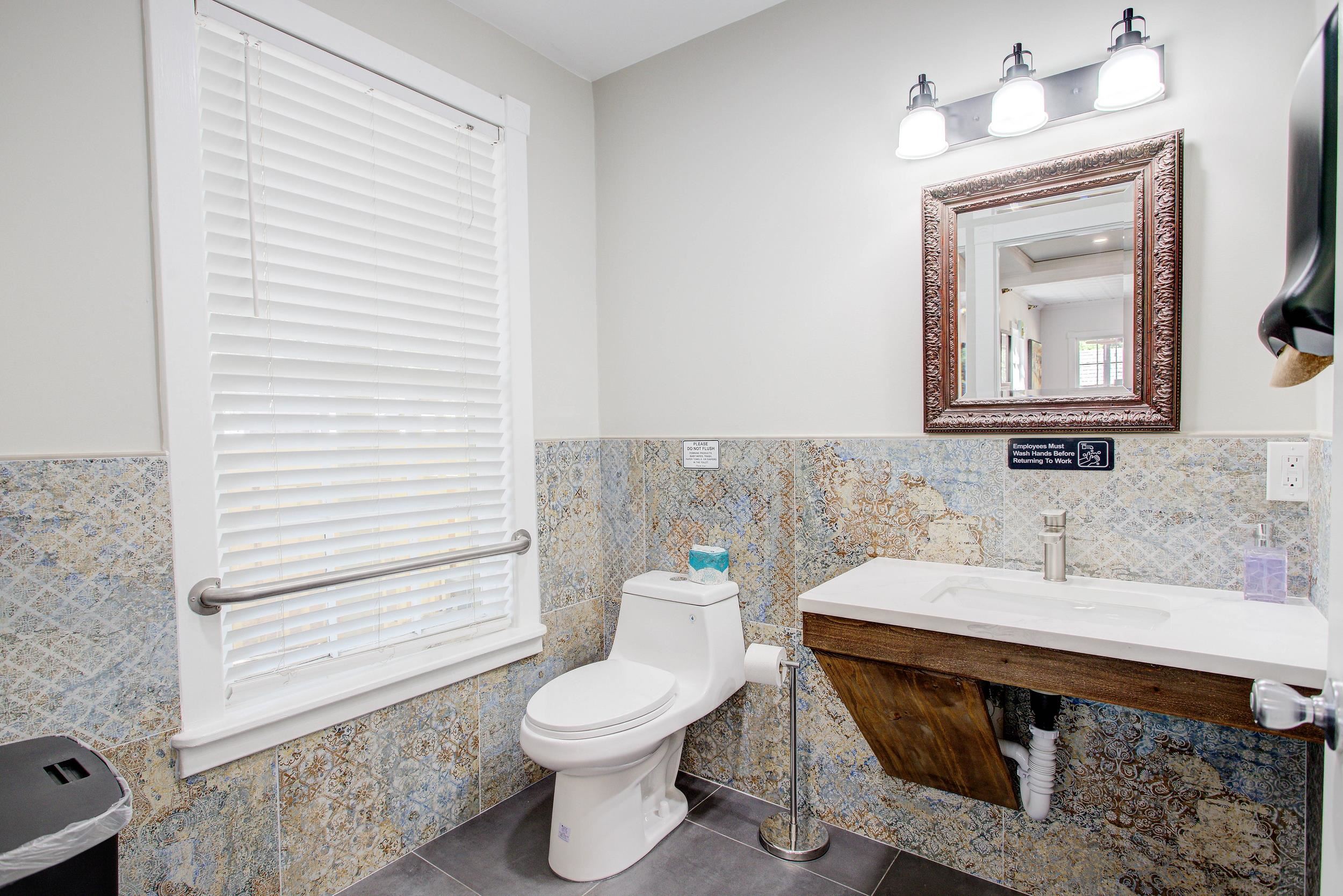 29 Cuna Street St. Augustine, FL 32084 - Photo 31 of 69 Half bath with tile walls, dark tile patterned flooring, a wainscoted wall, and vanity