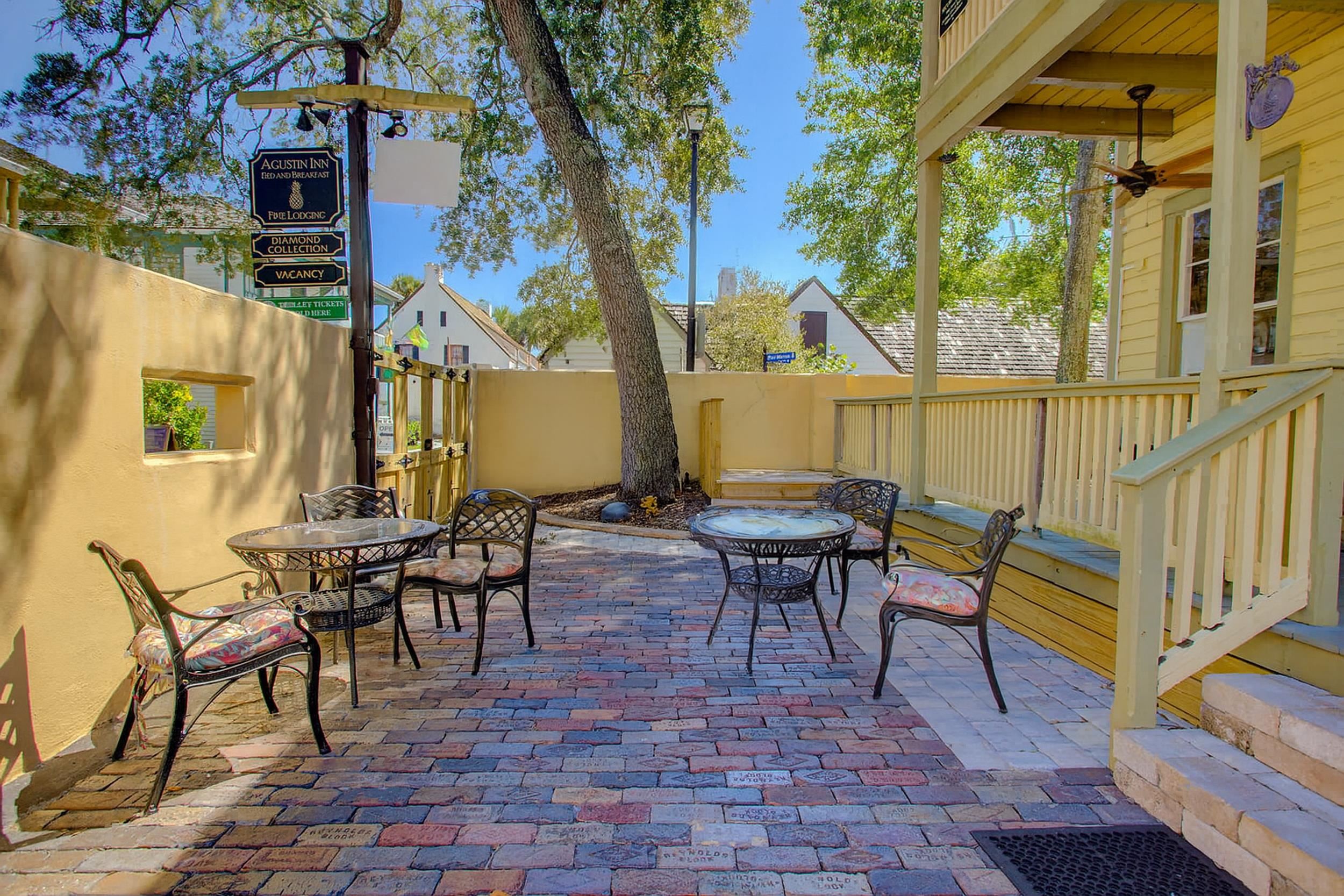 29 Cuna Street St. Augustine, FL 32084 - Photo 8 of 69 a view of a patio with table and chairs and floor to ceiling window plants and wooden fence