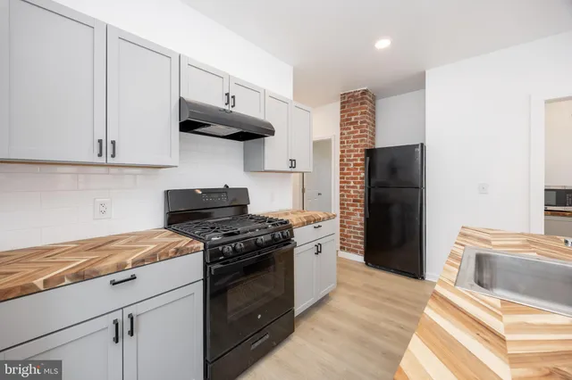 a kitchen with stainless steel appliances a stove a refrigerator and a cabinets