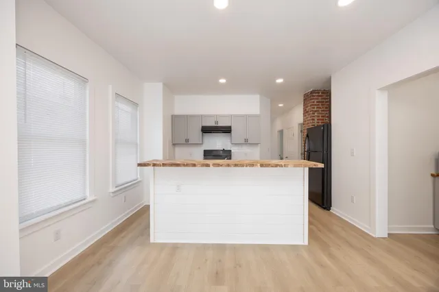 a view of kitchen with stainless steel appliances granite countertop cabinets and wooden floor