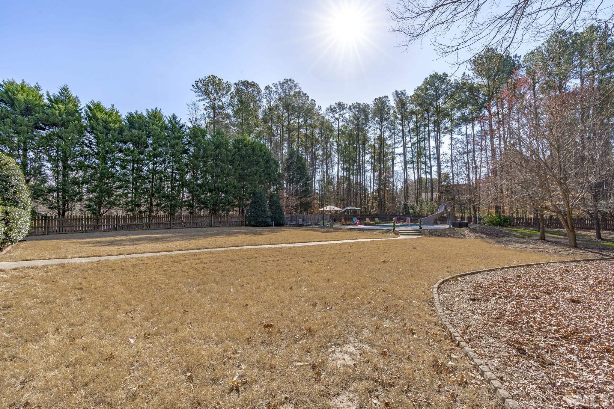 2904 Sunnystone Way Raleigh, NC 27613 - Photo 50 of 51 a view of swimming pool with outdoor seating and trees in the background