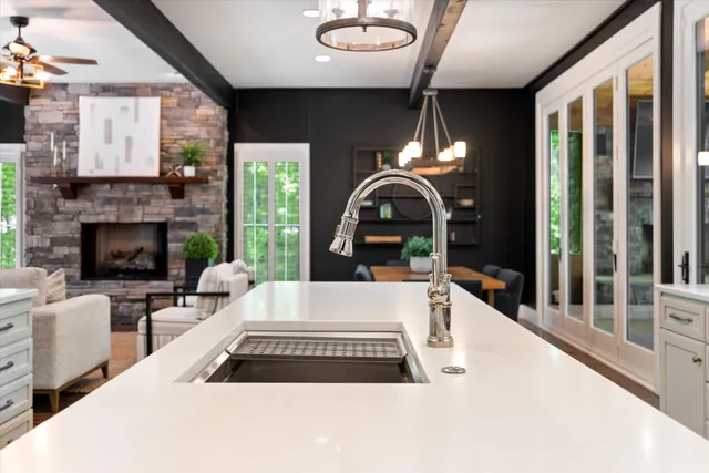 a utility room with stainless steel appliances granite countertop a sink and cabinets