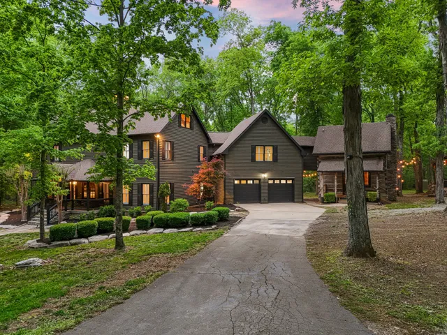 a front view of a house with a yard and green space