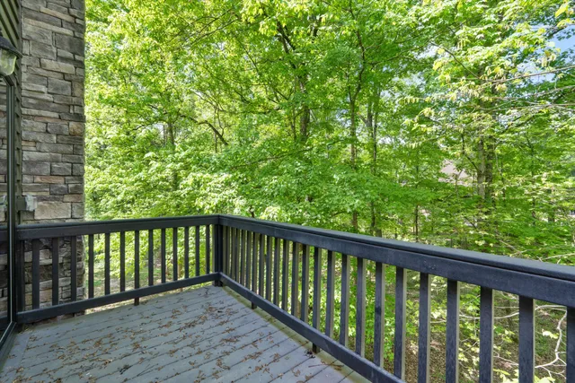a view of house with wooden deck and furniture