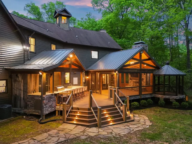 an aerial view of a house with swimming pool and next to a yard