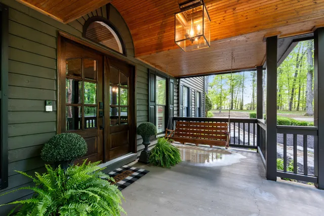 a view of a porch with furniture and floor to ceiling window