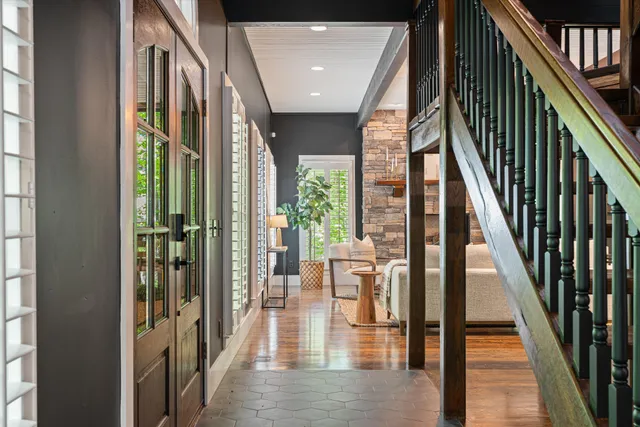 a living room with furniture a fireplace and a large window