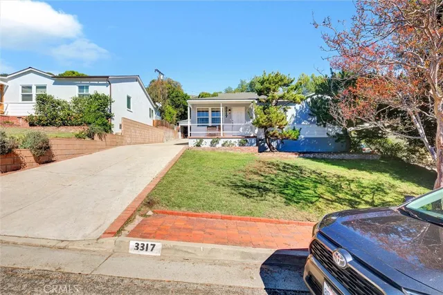 a view of a backyard with plants and patio