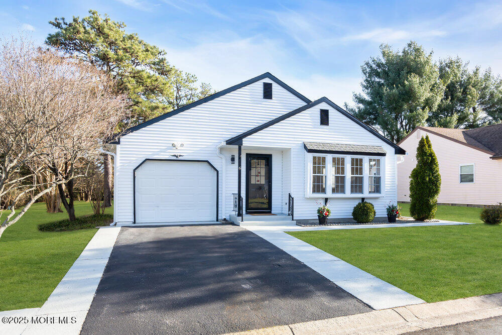 a front view of a house with a yard and trees