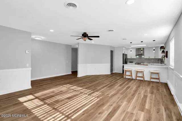 a large white kitchen with kitchen island a sink stainless steel appliances and cabinets