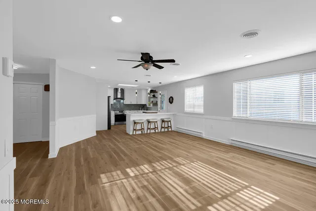a view of a room with wooden floor and a ceiling fan