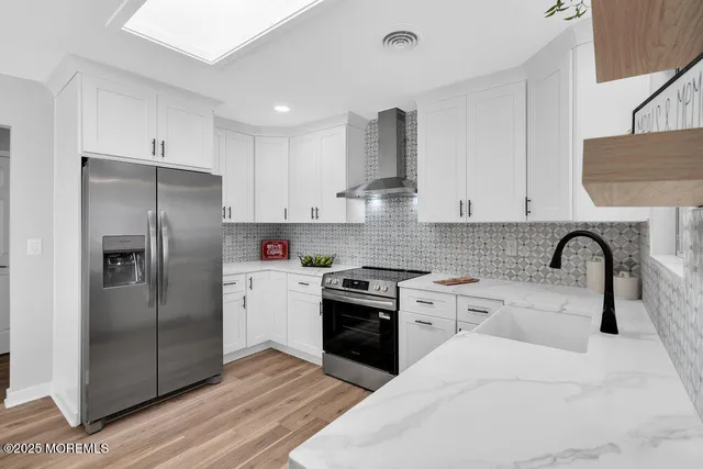 a kitchen with stainless steel appliances granite countertop a refrigerator sink and stove