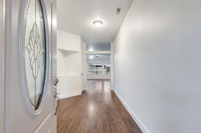 a view of a hallway with wooden floor