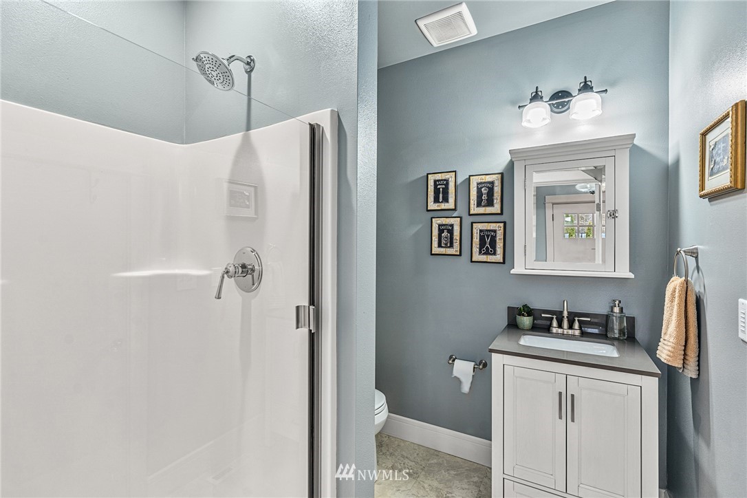 3020 Gedney Street Everett, WA 98201 - Photo 16 of 40 a bathroom with a granite countertop sink a mirror a vanity and a shower