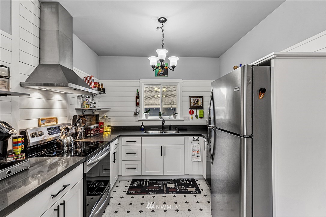 3020 Gedney Street Everett, WA 98201 - Photo 25 of 40 a kitchen with granite countertop a sink stainless steel appliances a counter space and cabinets