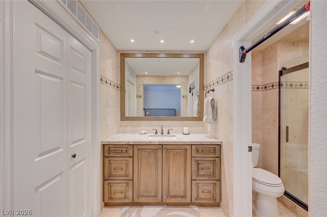 230 East Flamingo Road, Unit 106 Las Vegas, NV 89169 - Photo 14 of 66 A refined bathroom featuring a light wood vanity, granite counters, and a spacious framed mirror.