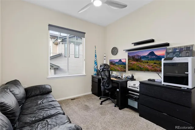 a living room with furniture a flat screen tv and floor to ceiling window