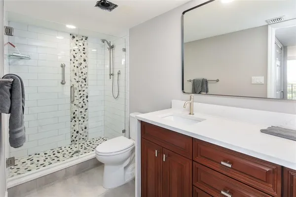 a bathroom with a sink a toilet and shower