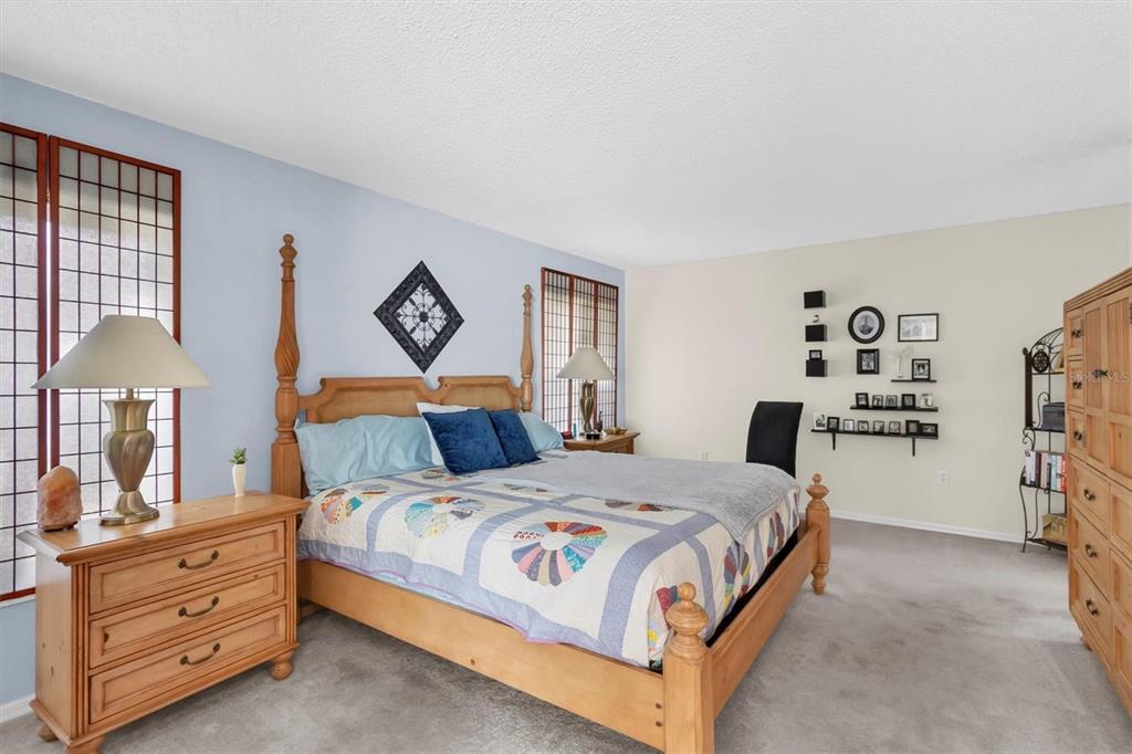 11634 Wheatfield Loop Hudson, FL 34667 - Photo 16 of 38 a bedroom with a bed and a lamp on table