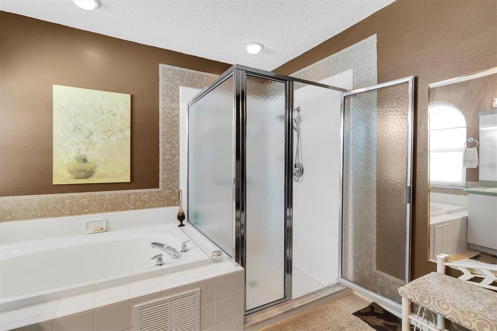 11634 Wheatfield Loop Hudson, FL 34667 - Photo 18 of 38 a bathroom with a tub a sink and a mirror