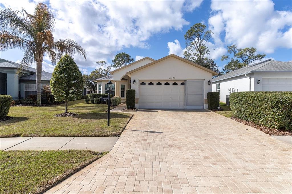 11634 Wheatfield Loop Hudson, FL 34667 - Photo 2 of 38 a view of a white house with a yard
