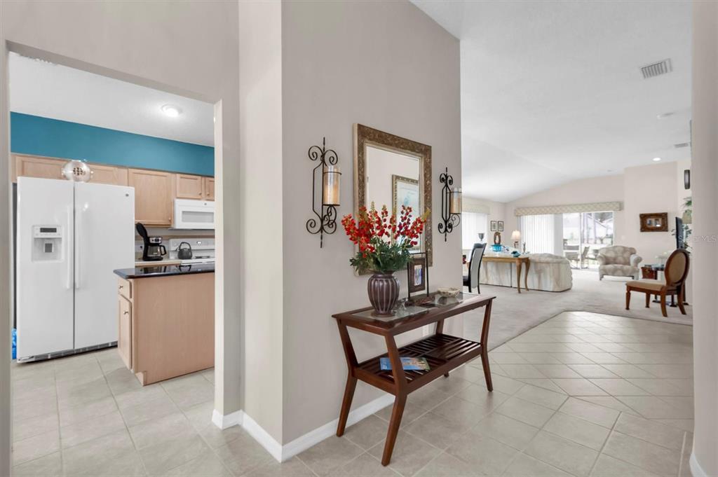 11634 Wheatfield Loop Hudson, FL 34667 - Photo 3 of 38 a hallway with a dining table and chairs