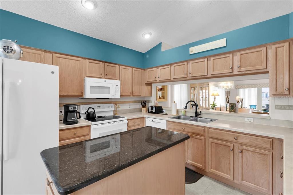 11634 Wheatfield Loop Hudson, FL 34667 - Photo 5 of 38 a kitchen with stainless steel appliances granite countertop a sink stove and refrigerator