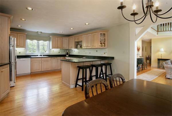 11 Brookmill Road Stow, MA 01775 - Photo 6 of 8 a kitchen with stainless steel appliances granite countertop a stove top oven a sink a dining table and chairs with wooden floor