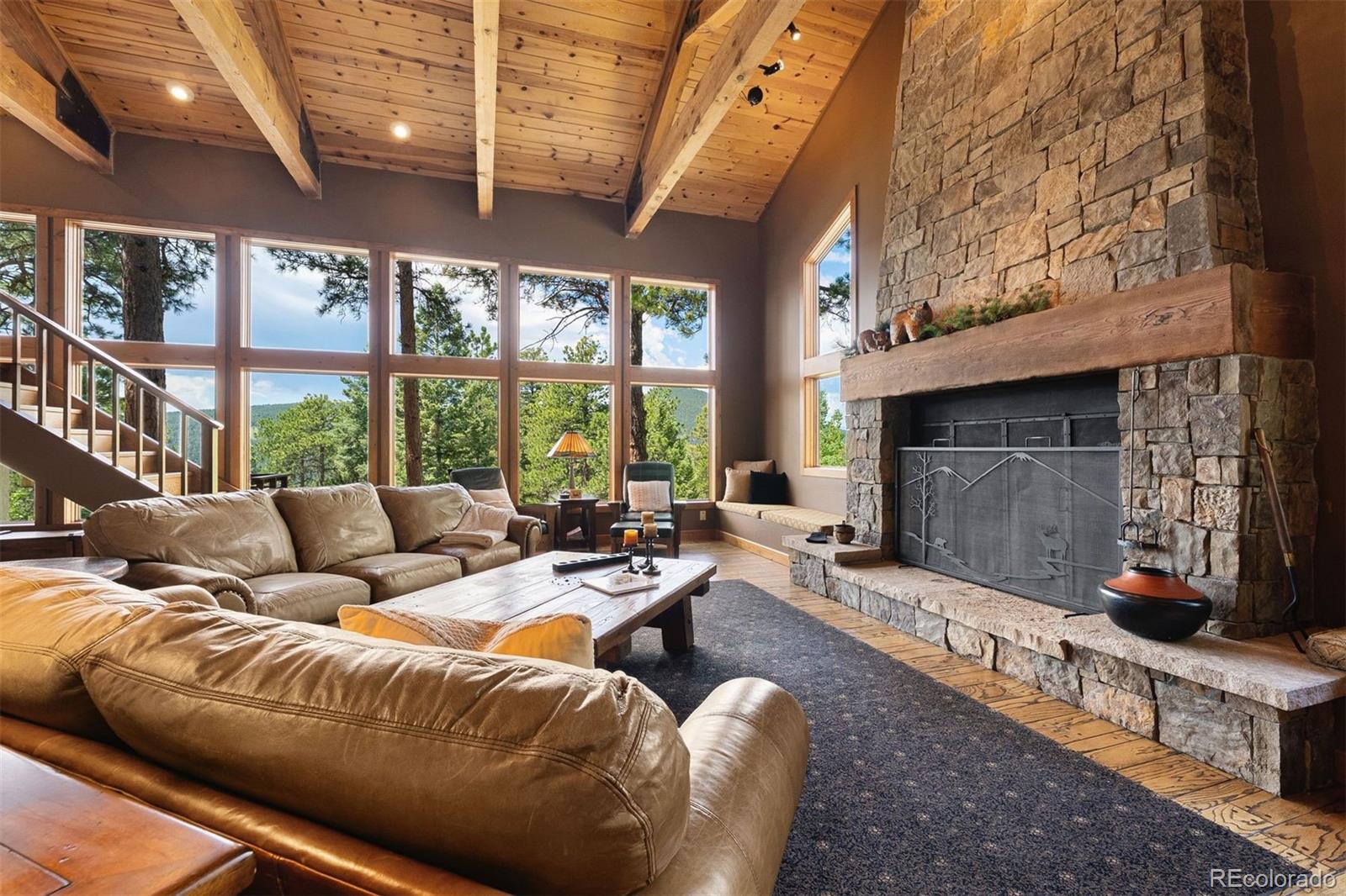 12351 South Ridge Road Conifer, CO 80433 - Photo 11 of 50 a living room with furniture a large window and a fireplace