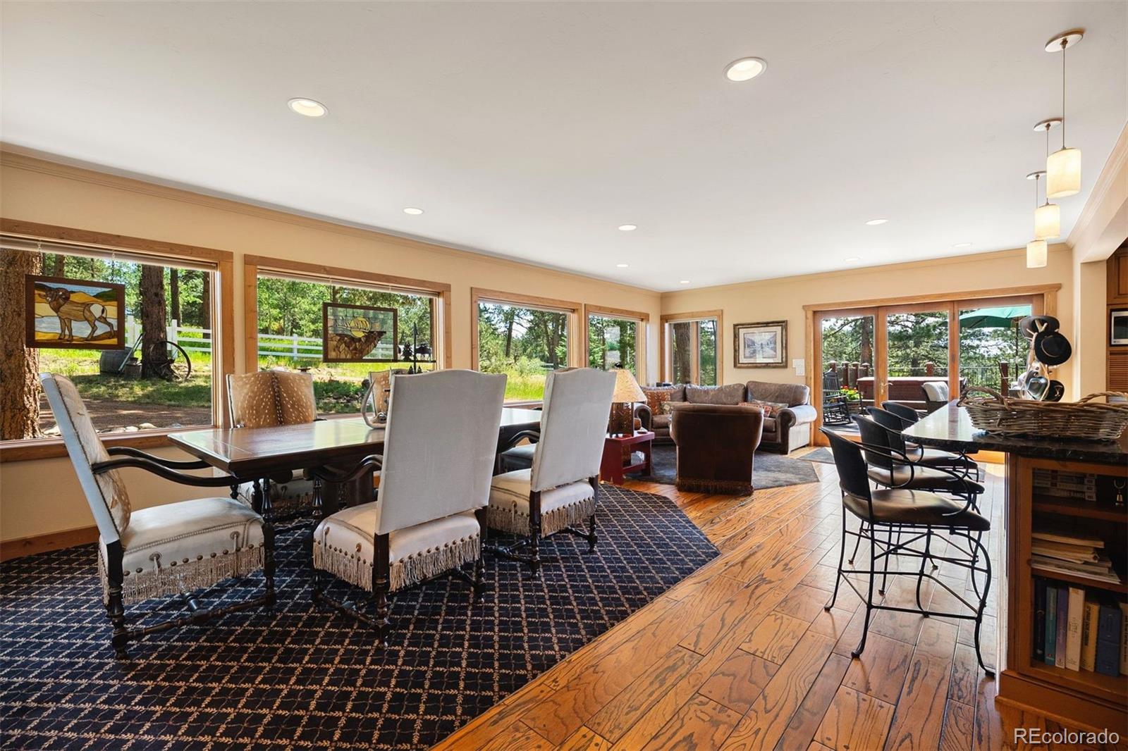 12351 South Ridge Road Conifer, CO 80433 - Photo 13 of 50 a dining room with wooden floor a glass table and chairs