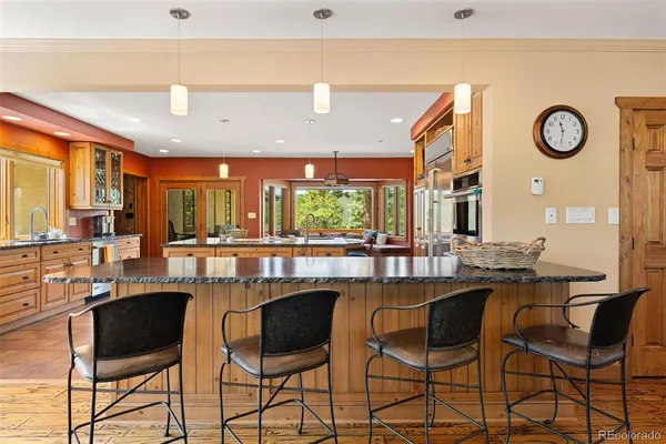 a dining hall with stainless steel appliances kitchen island granite countertop a table and chairs
