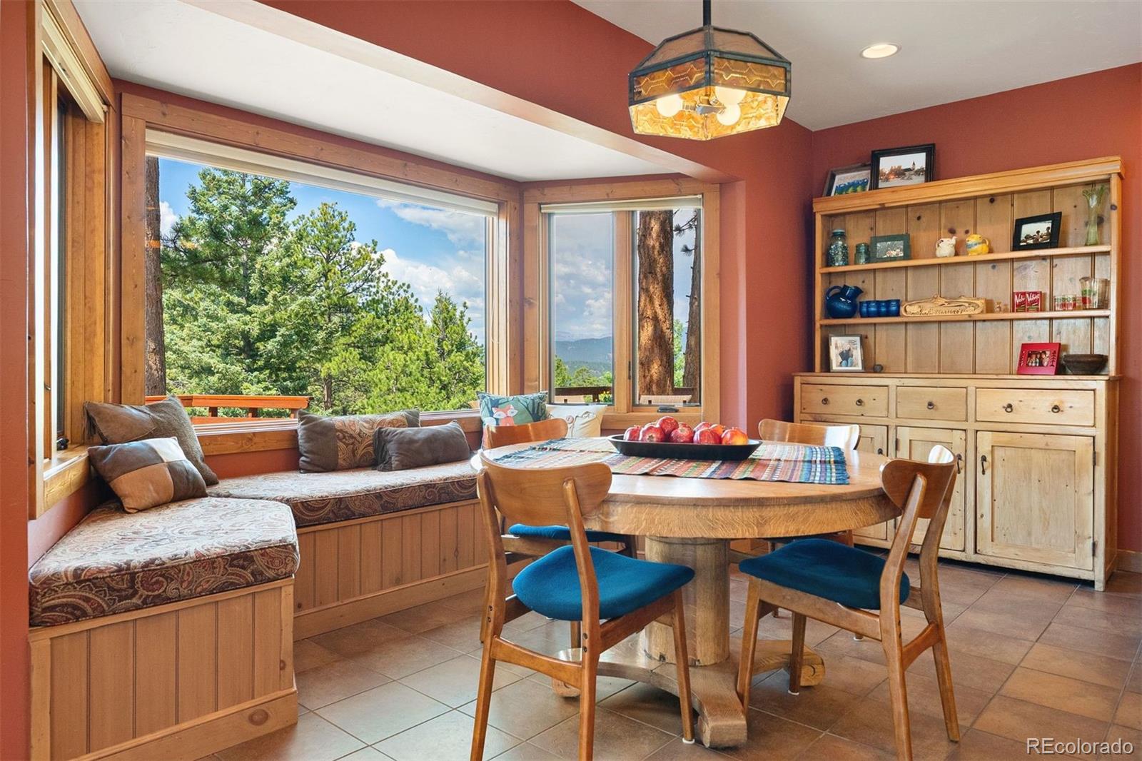 12351 South Ridge Road Conifer, CO 80433 - Photo 20 of 50 a dining room with furniture a rug and a floor to ceiling window
