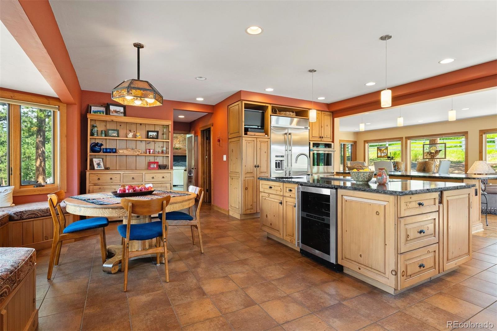 12351 South Ridge Road Conifer, CO 80433 - Photo 21 of 50 a kitchen with stainless steel appliances kitchen island granite countertop a table chairs and a chandelier